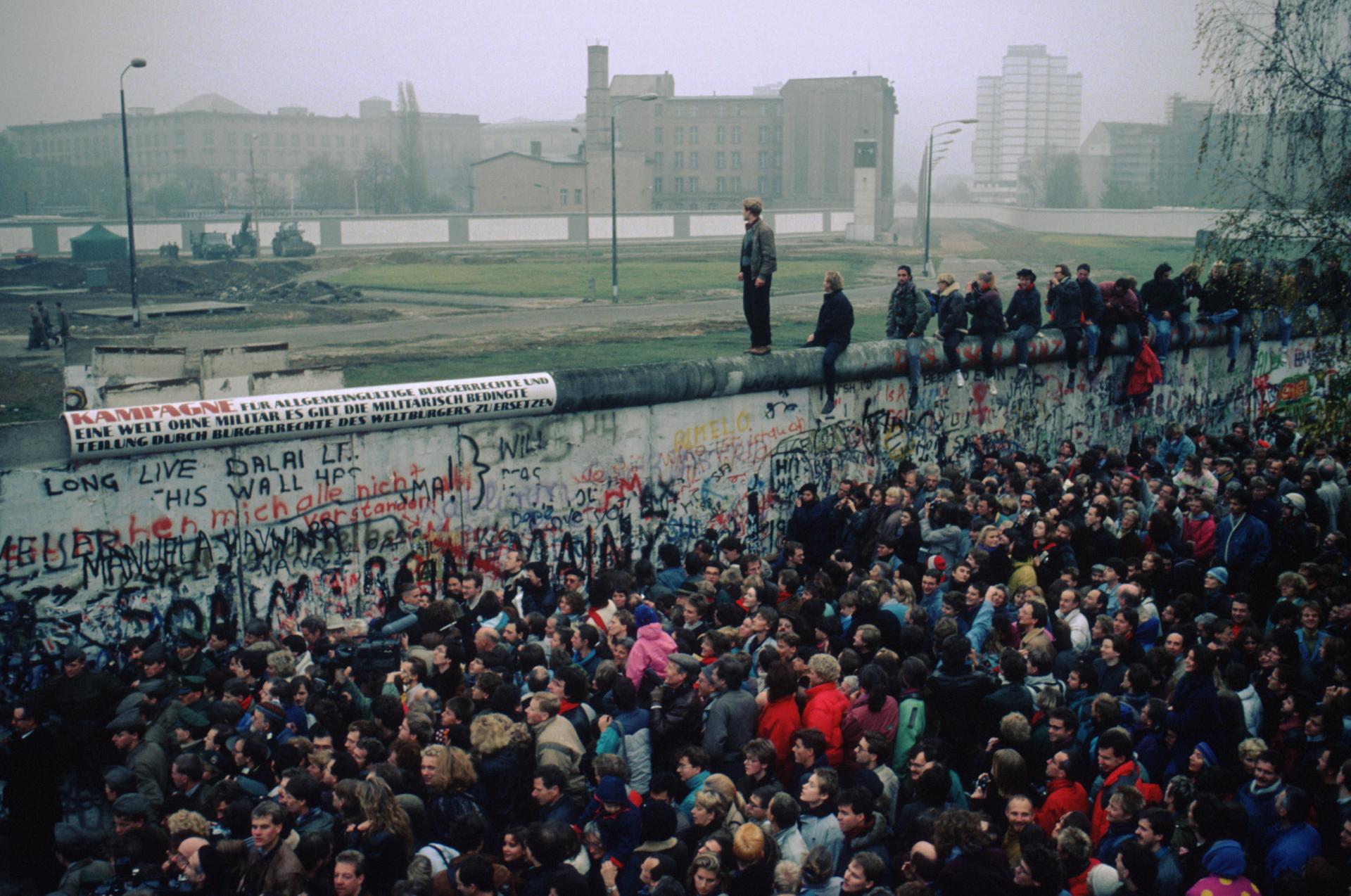 Người dân tụ tập tại Bức tường Berlin sau khi biên giới mở cửa vào ngày 9/11/1989. (Thomas Imo/Photothek/Getty Images)