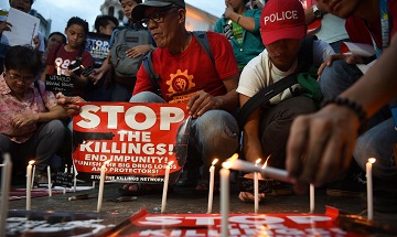 Những nhà hoạt động đốt nến trước một nhà thờ ở Manila trong lễ thắp nến tưởng niệm các nạn nhân của các vụ giết người không đúng quy trình tư pháp trong cuộc chiến chống ma túy của chính phủ. (Ảnh: Ted Aljibe/AFP/Getty Images)